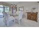 Formal dining room with elegant chandelier, glass table and white chairs, great for entertaining at 302 Woodingham Ct, Venice, FL 34292