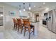 Open-concept kitchen with stainless steel appliances, granite countertops, and a breakfast bar at 302 Woodingham Ct, Venice, FL 34292