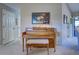 Hallway featuring a piano with a padded bench and decorative painting at 302 Woodingham Ct, Venice, FL 34292