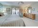 Bright bedroom with a large dresser, framed art, and a sliding glass door to the outdoor patio area at 302 Woodingham Ct, Venice, FL 34292