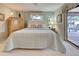 Inviting bedroom with a plush bed, side tables, and an outdoor view through a glass patio door to the pool at 302 Woodingham Ct, Venice, FL 34292