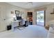 Well-lit office with a work desk, shelving, and a sliding door leading to the outdoor pool area at 302 Woodingham Ct, Venice, FL 34292