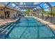 Screened pool area with brick flooring and view of the lush landscaping and blue skies at 302 Woodingham Ct, Venice, FL 34292