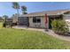 Backyard featuring green lawn, tropical palm trees, enclosed lanai, and patio set at 3020 Sail Pointe Cir # 5A, Venice, FL 34293