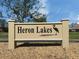 Entrance sign for Heron Lakes community, enhanced by landscaped grounds at 3020 Sail Pointe Cir # 5A, Venice, FL 34293