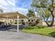 Exterior view showcasing the carport, landscaping, and the home's well-maintained lawn at 3020 Sail Pointe Cir # 5A, Venice, FL 34293