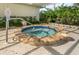 Hot tub featuring brick trim, with clear blue water and mature landscaping at 3020 Sail Pointe Cir # 5A, Venice, FL 34293