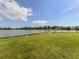 Expansive green lawn leading to a serene lake with a wooded shoreline at 3020 Sail Pointe Cir # 5A, Venice, FL 34293