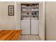 Inside laundry room with side-by-side washer and dryer and wire shelving at 3020 Sail Pointe Cir # 5A, Venice, FL 34293