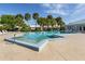 Community pool is surrounded by lush palm trees and lounge chairs at 3020 Sail Pointe Cir # 5A, Venice, FL 34293