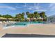 Outdoor pool features clear water, lounge chairs, tropical landscaping, and clear blue skies at 3020 Sail Pointe Cir # 5A, Venice, FL 34293