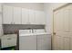 Well-lit laundry room with washer, dryer, and storage cabinets at 3415 N Cranberry Blvd, North Port, FL 34286