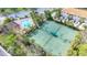 Aerial view showcasing the tennis courts, community pool, and playground surrounded by lush greenery at 3730 82Nd Avenue E Cir # 104, Sarasota, FL 34243