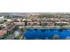 Stunning aerial view of the community featuring lush landscaping, a tranquil lake, and beautiful terracotta rooftops at 3730 82Nd Avenue E Cir # 104, Sarasota, FL 34243