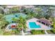 Aerial view of a community pool, tennis courts, and playground surrounded by lush landscaping and palm trees at 3730 82Nd Avenue E Cir # 104, Sarasota, FL 34243