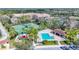 Aerial view of a community pool, tennis courts, and playground surrounded by lush landscaping and palm trees at 3730 82Nd Avenue E Cir # 104, Sarasota, FL 34243