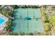 Aerial view of well-maintained tennis courts surrounded by lush landscaping and mature trees in a gated community at 3730 82Nd Avenue E Cir # 104, Sarasota, FL 34243