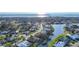 Aerial view of community with waterfront homes under sunny skies, palm trees, and manicured landscaping at 389 Eden Dr, Englewood, FL 34223