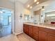 Bright bathroom featuring double sinks, granite countertops, decorative rug, and tiled floors at 389 Eden Dr, Englewood, FL 34223