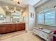 Bright bathroom featuring double sinks, granite countertops, decorative rug, and tiled floors at 389 Eden Dr, Englewood, FL 34223