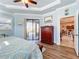 Main bedroom featuring tray ceilings, wood flooring, and sliding glass doors to the pool at 389 Eden Dr, Englewood, FL 34223