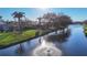 Picturesque view of the home from across the water, showcasing lush landscaping and palm trees at 389 Eden Dr, Englewood, FL 34223