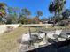 Well-maintained backyard with a white picket fence, mature trees, and outdoor seating at 4052 Holin Ln, North Port, FL 34287