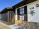 Close up of the front door, porch and home address on a well-maintained home with stone accents at 4052 Holin Ln, North Port, FL 34287