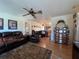 Cozy living room featuring hardwood floors, a ceiling fan, an open layout, and an adjacent kitchen at 4052 Holin Ln, North Port, FL 34287