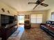 Comfortable living room featuring a ceiling fan, plush seating, and ample natural light at 4052 Holin Ln, North Port, FL 34287