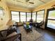 Relaxing sunroom filled with wicker furniture, a ceiling fan, and natural light from the large windows at 4052 Holin Ln, North Port, FL 34287