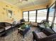 Cozy sunroom featuring wicker furniture, a glass coffee table, and a colorful floral rug at 4052 Holin Ln, North Port, FL 34287