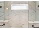 Walk-in shower with marble tile and a window at 4309 Renwick Dr, Parrish, FL 34219