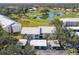 Aerial view of the condo complex featuring mature trees, golf course and lovely pond at 435 Cerromar Ln # 328, Venice, FL 34293