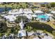 Aerial view of the community center, pool, and golf course surrounded by lush landscaping and scenic ponds at 435 Cerromar Ln # 328, Venice, FL 34293