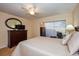 Cozy bedroom featuring a ceiling fan, dresser with television, and a comfortable chair near window at 435 Cerromar Ln # 328, Venice, FL 34293