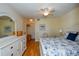 Bright bedroom with wood floors featuring ensuite bath, dresser, and large windows at 435 Cerromar Ln # 328, Venice, FL 34293