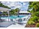 Community pool with lounge chairs and umbrellas surrounded by palm trees at 435 Cerromar Ln # 328, Venice, FL 34293