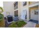 Exterior view of condo with white trim, light-colored siding, AC Unit, and small landscaping at 435 Cerromar Ln # 328, Venice, FL 34293