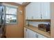 Bright kitchen with white cabinets, stainless steel toaster, and view from a window at 435 Cerromar Ln # 328, Venice, FL 34293