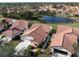 Aerial view of homes with red tile roofs, well-manicured lawns, and scenic lake views in the community at 4951 Summertree Rd, Venice, FL 34293