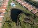 Aerial view of community with pool, pond, landscaping and tile roofs at 4951 Summertree Rd, Venice, FL 34293