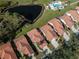 Aerial view of a home with a tile roof in a green community with pond and pool at 4951 Summertree Rd, Venice, FL 34293