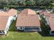 Aerial view of homes with red tile roofs, green lawns, and mature trees, and a screened in porch at 4951 Summertree Rd, Venice, FL 34293