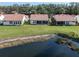 Back exterior view of home with a pond and a well manicured lawn at 4951 Summertree Rd, Venice, FL 34293