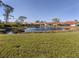 Scenic view of a serene pond surrounded by well-maintained homes and lush greenery in the community at 4951 Summertree Rd, Venice, FL 34293