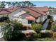 Beautiful home with red tile roof, white stucco, mature landscaping, and close proximity to neighborhood lake at 4951 Summertree Rd, Venice, FL 34293