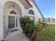 Charming front entrance features a 'welcome' mat, an arched window and meticulous landscaping at 4951 Summertree Rd, Venice, FL 34293