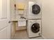 Functional laundry area with stacked washer/dryer unit and convenient shelving at 4951 Summertree Rd, Venice, FL 34293