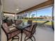 Enclosed patio featuring a ceiling fan and peaceful view of the lawn and lake at 4951 Summertree Rd, Venice, FL 34293